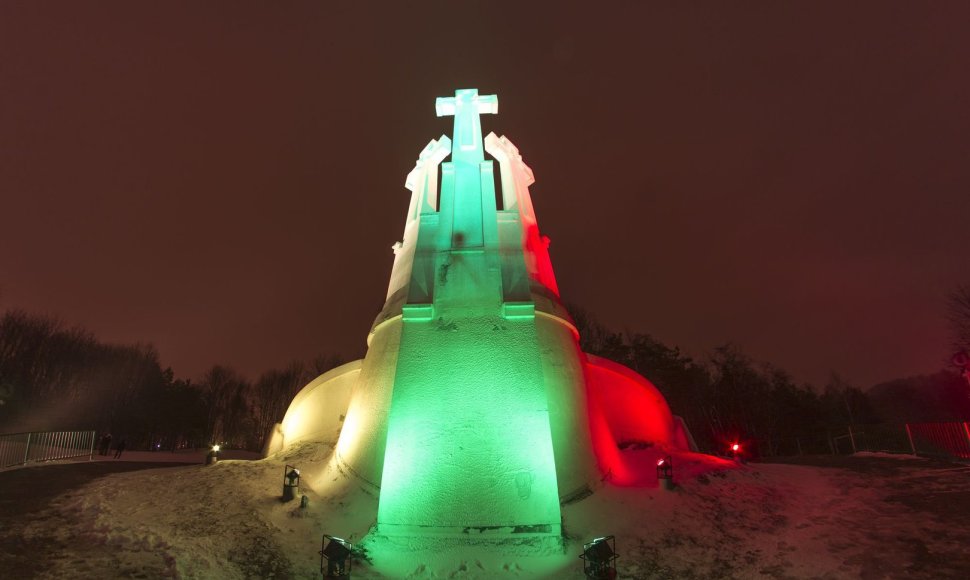 Lietuvos vėliavos spalvomis apšviestas „Trijų kryžių“ paminklas