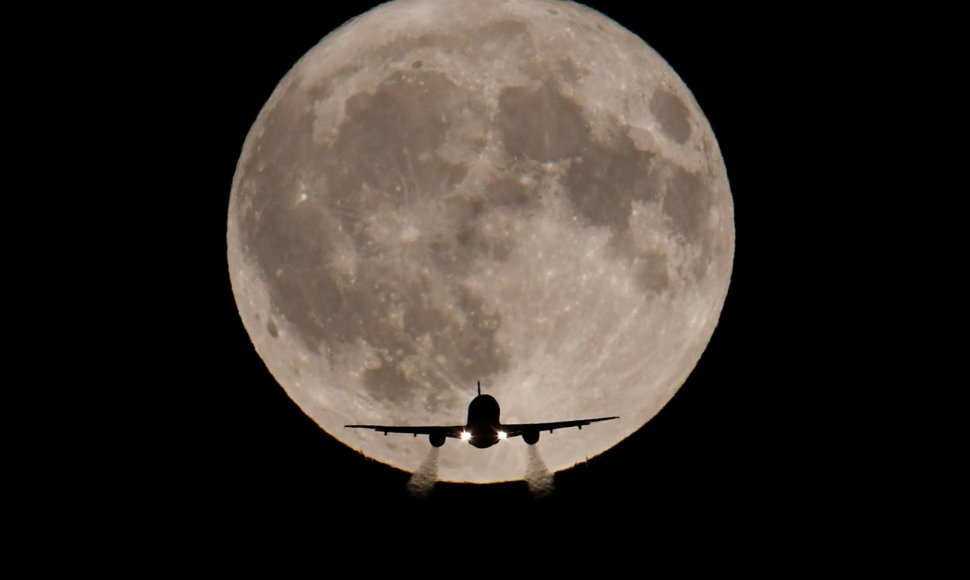 Londone kylantis lėktuvas mėnulio pilnaties fone