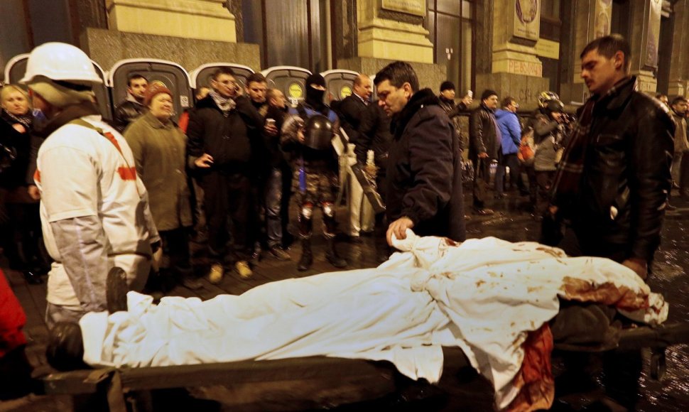 Tėvas laiko savo žuvusio sunaus ranką, kurio gyvybė užgeso per protestus Kijeve