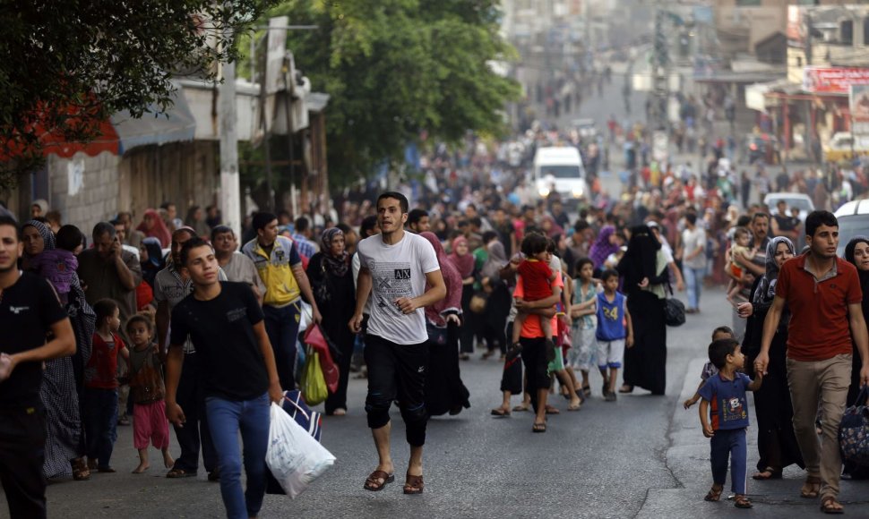 Palestiniečiai bėga iš bombarduojamo Šedžajos rajono