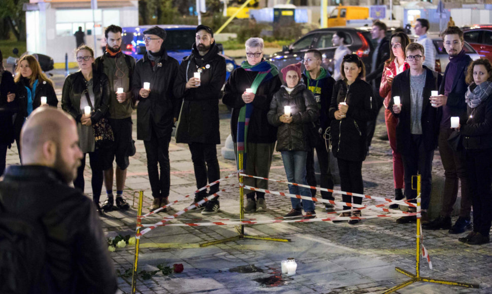 Žmonės laiko žvakes vietoje, kurioje bandė susideginti prieš vyriausybę protestavęs lenkas