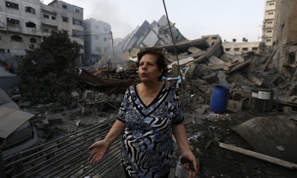 Gazos Ruože moteris prie pastato griuvėsių