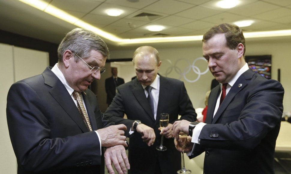 Tarptautinio olimpinio komiteto prezidentas Thomas Bachas, Rusijos prezidentas Vladimiras Putinas ir Rusijos ministras pirmininkas žiūri į laikrodžius per Sočio olimpinių žaidynių uždarymo cermoniją.