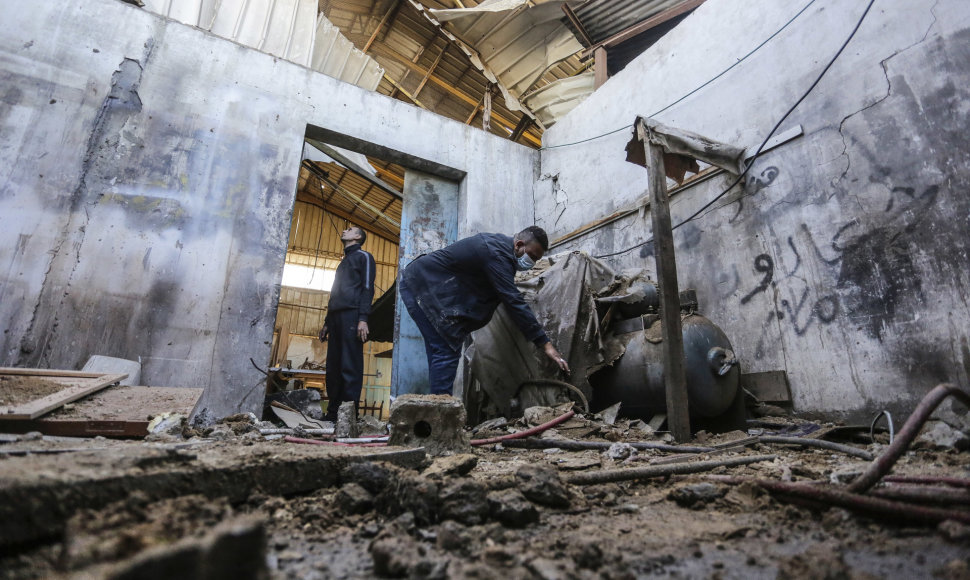Palestiniečiai apžiūrinėja Izraelio oro smūgio metu sugriautas dirbtuves
