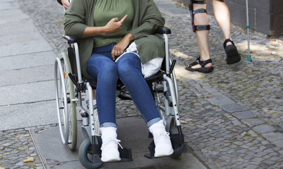 Moteris neįgaliojo vežimėlyje