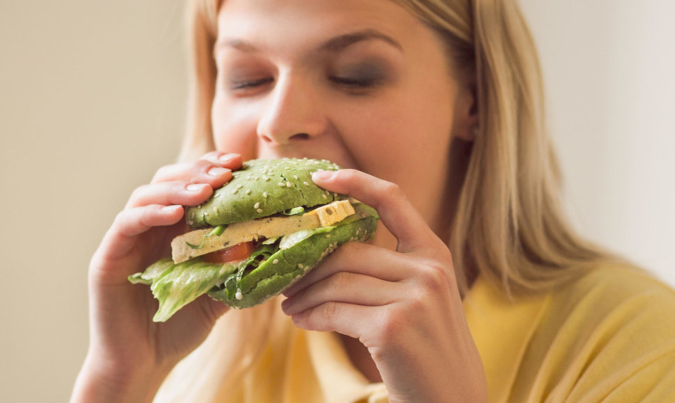 Moteris valgo veganišką burgerį