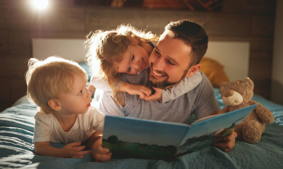 Tėtis vaikams skaito knygą