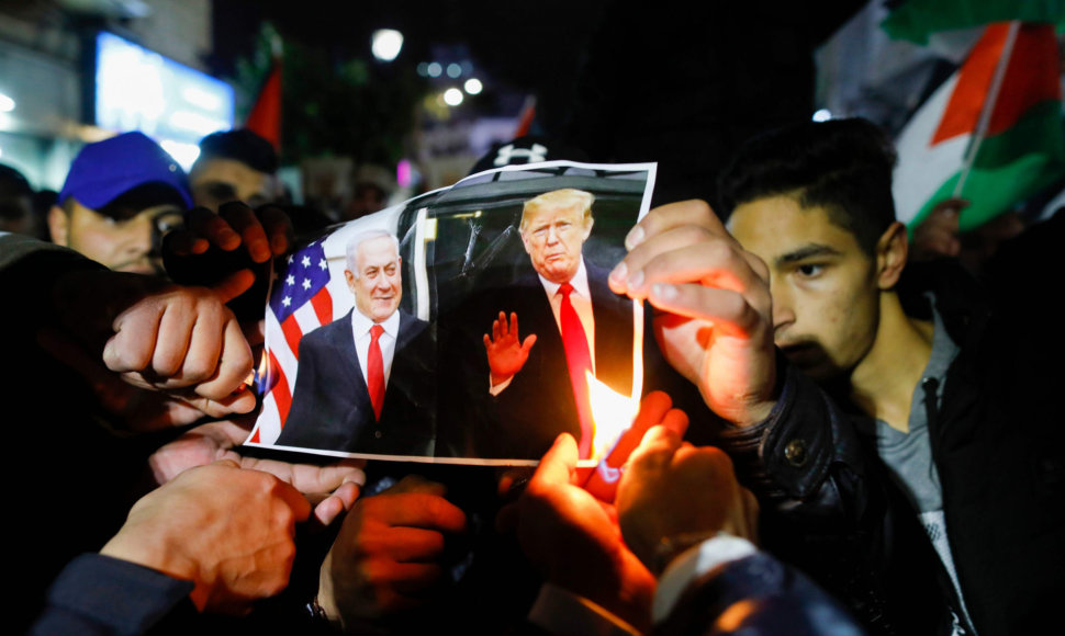 Ramaloje protestuojantys palestiniečiai degina D.Trumpo ir B.Netanyahu nuotrauką.