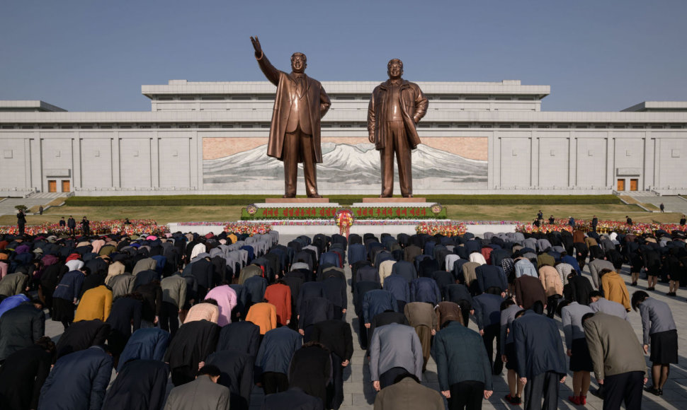Žmonės prie Kim Il Sungo (kairėje) ir Kim Jong Ilo statulų