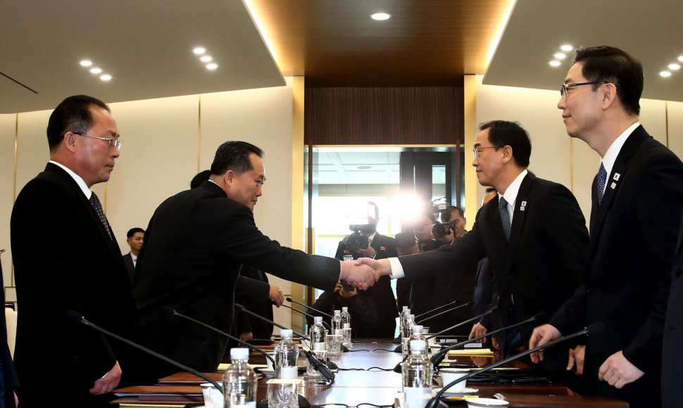 Sveikinasi Pietų Korėjos susivienijimo ministras Cho Myoung-gyonas (antras iš dešinės) ir Šiaurės Korėjos delegacijos vadovas Ri Son Gwonas (antras iš kairės)