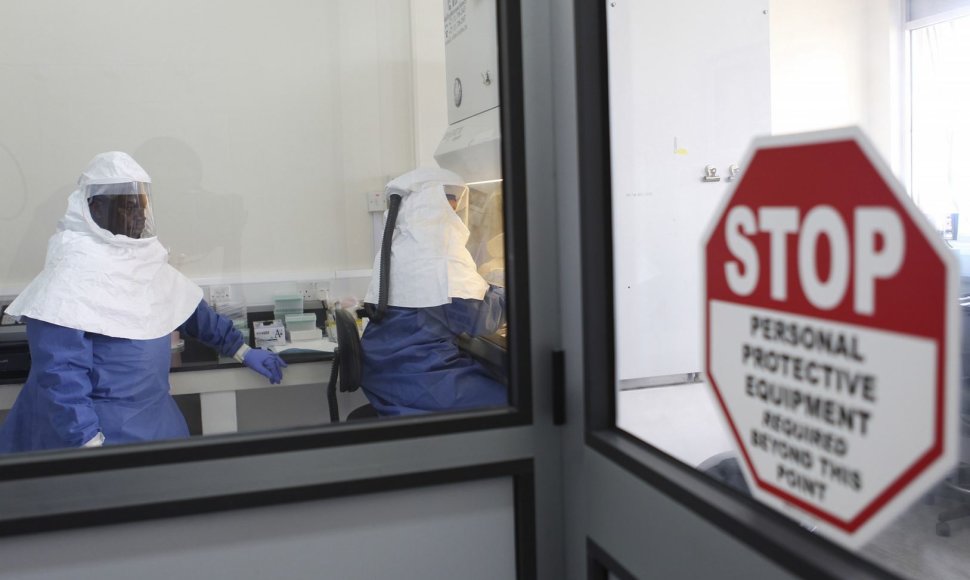 Gydytojai dirba su surinktais Ebola viruso mėginiais.