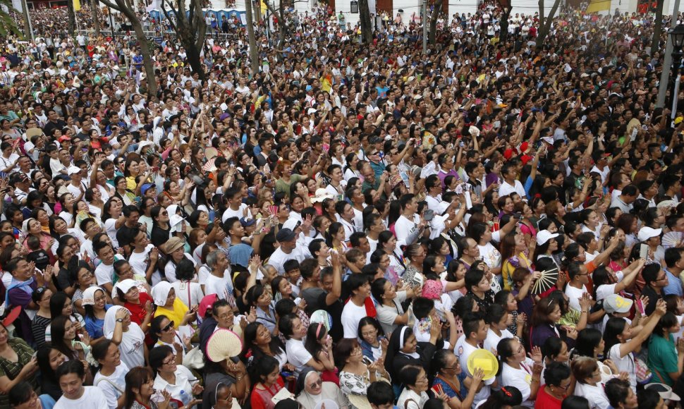 Popiežiui Pranciškui mojuojanti ir jį fotografuojanti žmonių minia Maniloje