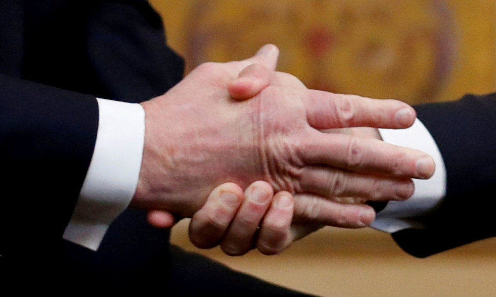 E.Macronas (kairėje) spaudžia ranką D.Trumpui