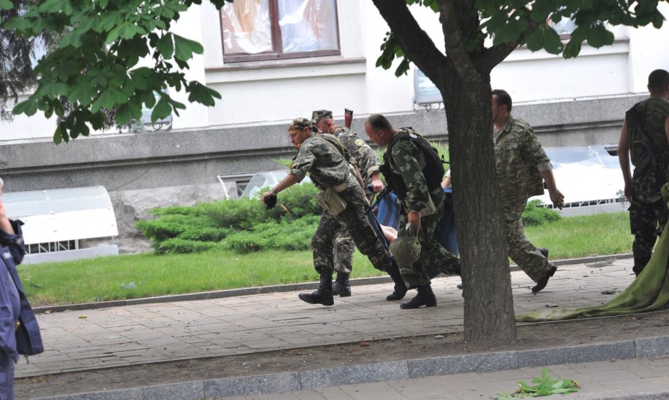 Luhanske prorusiški teroristai neša žuvusio kolegos kūną.