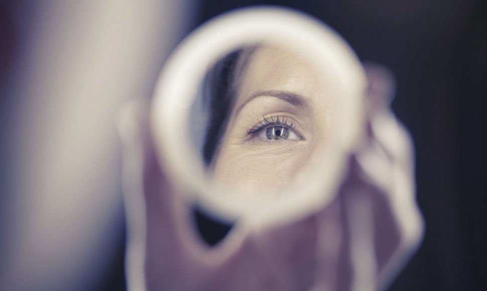 Moteris žiūri į veidrodį