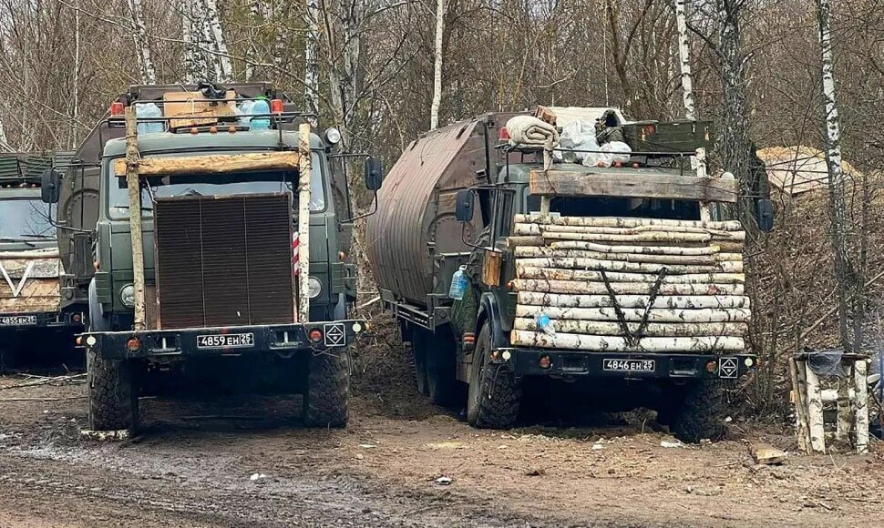 Rusijos sunkvežimiai, pridengti mediniais rąstais