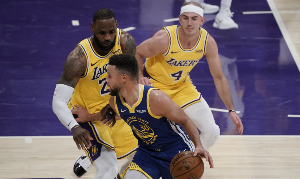 Stephenas Curry (su kamuoliu) prieš „Lakers“ gynybą