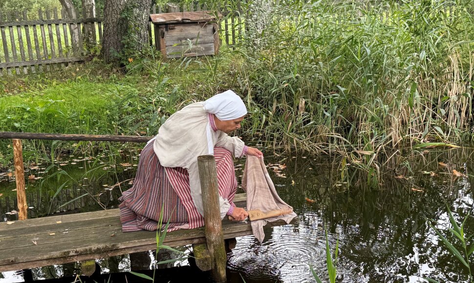 Moteris skalbia kūdroje