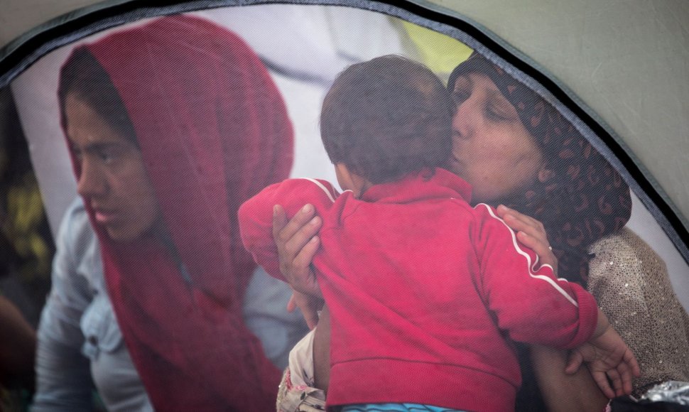Migrantai šalia Lesbo salos uosto laukia kelto į Atėnus.