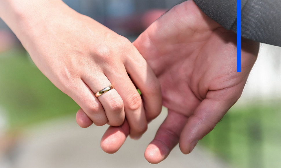 Moters ranką puošia vestuvinis žiedas