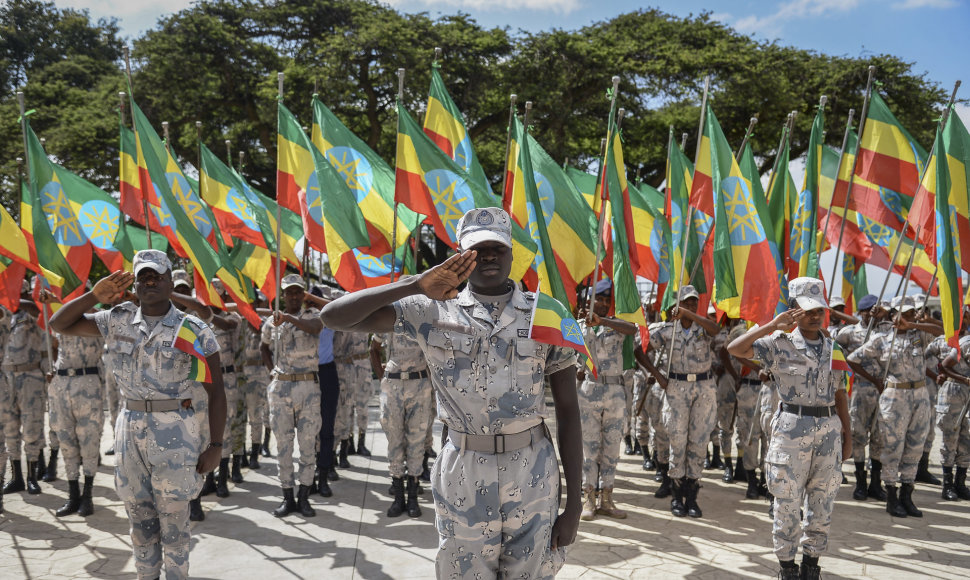 Etiopijos nacionalinės gynybos pajėgų nariai kelia nacionalines vėliavas pirmosios Tigrėjaus konflikto dienos aukoms pagerbti