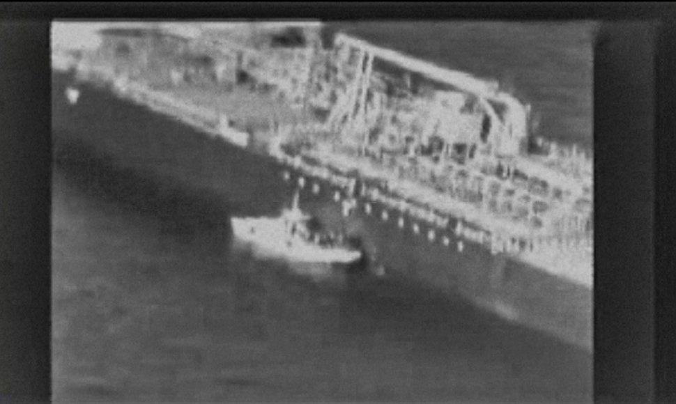 Kadras iš amerikiečių išplatinto vaizdo įrašo: iraniečiai nuplėšia miną nuo tanklaivio korpuso