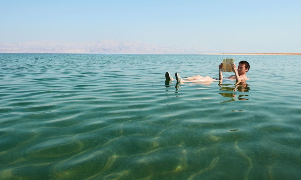 Kaukazietis skaito knygą plūduriuodamas Negyvojoje jūroje