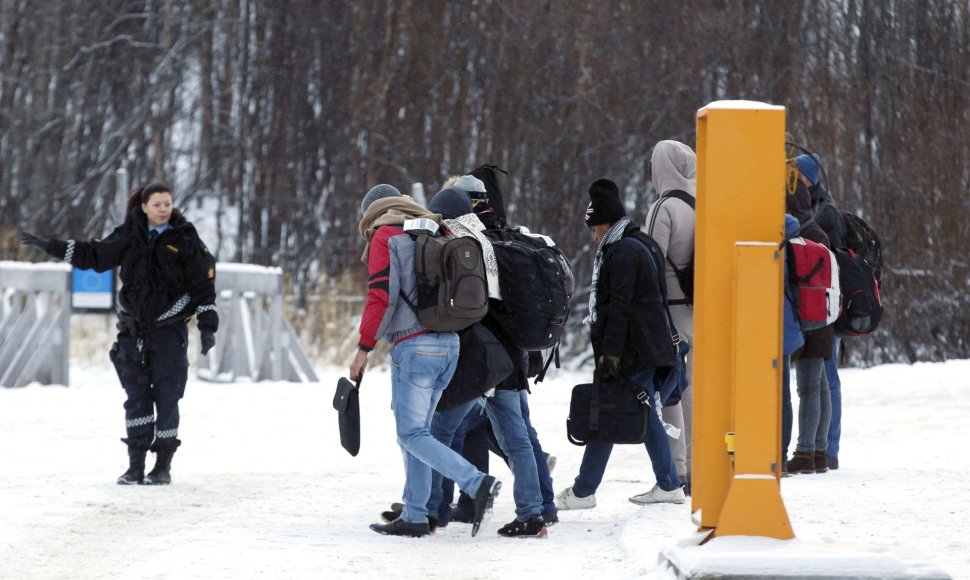 Norvegijos pasienio pareigūnė palydi migrantus