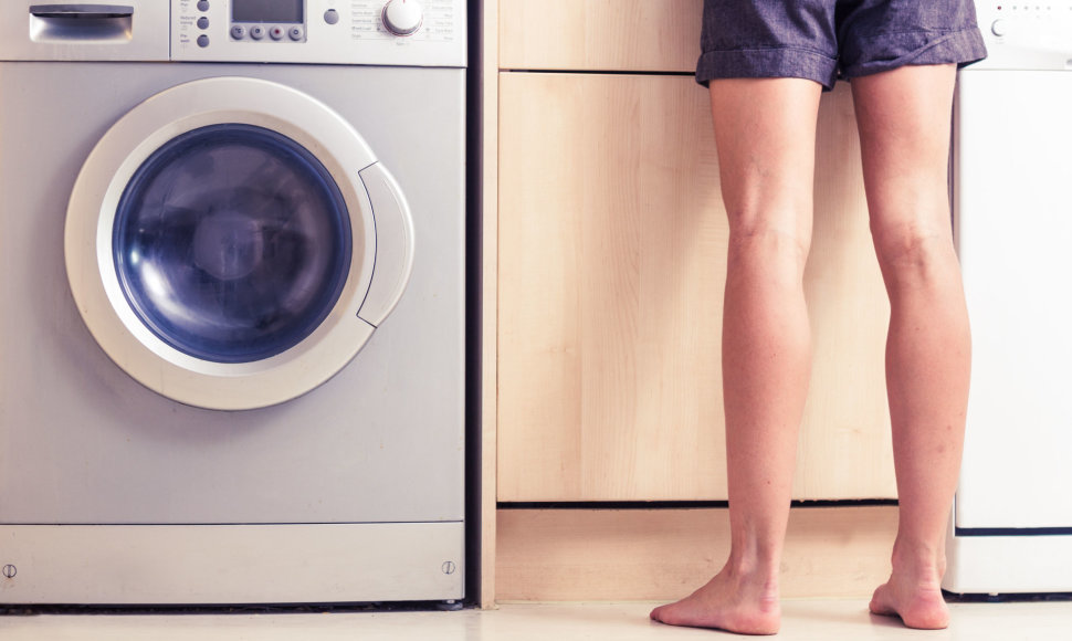 Moteris prie skalbimo mašinos