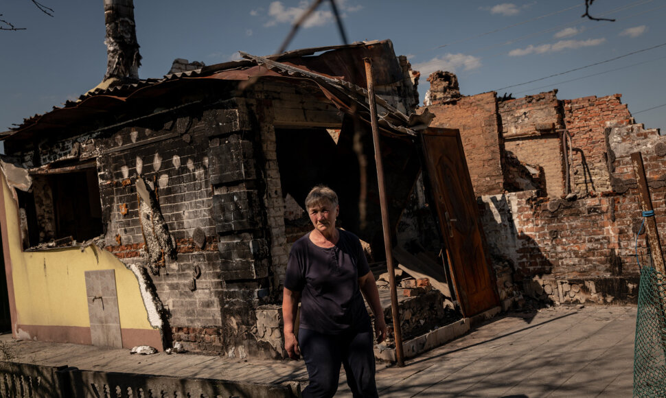 Moteris prie sugriauto namo Ukrainoje