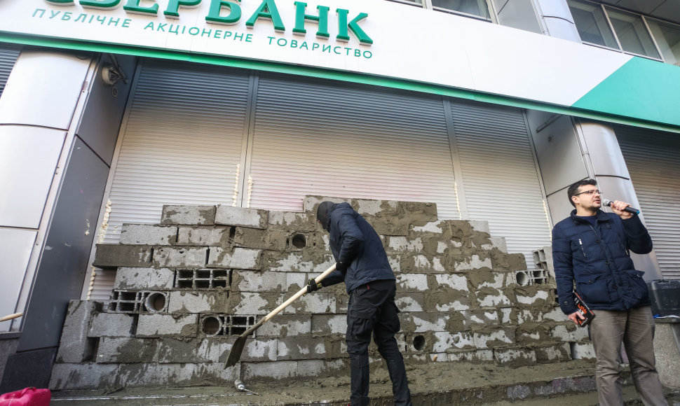 Kijeve simboliškai užmūrytas Rusijos „Sberbank“ pastatas, bankomatai apipurkšti montavimo putomis