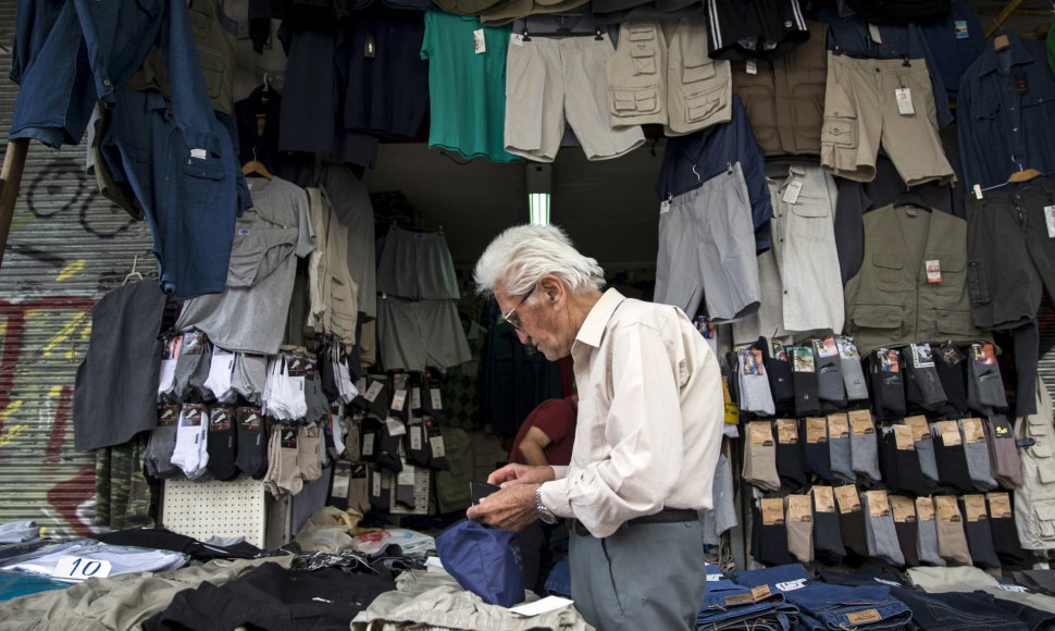 Vyriškis prie gatvėje įsikūrusios drabužių parduotuvės Atėnuose