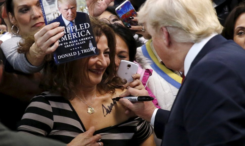 Donaldas Trumpas pasirašinėja ant moters kūno