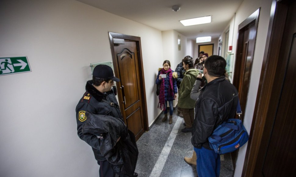 Policininkas „Laisvosios Europos“ radijo pastato koridoriuje su žurnalistais 