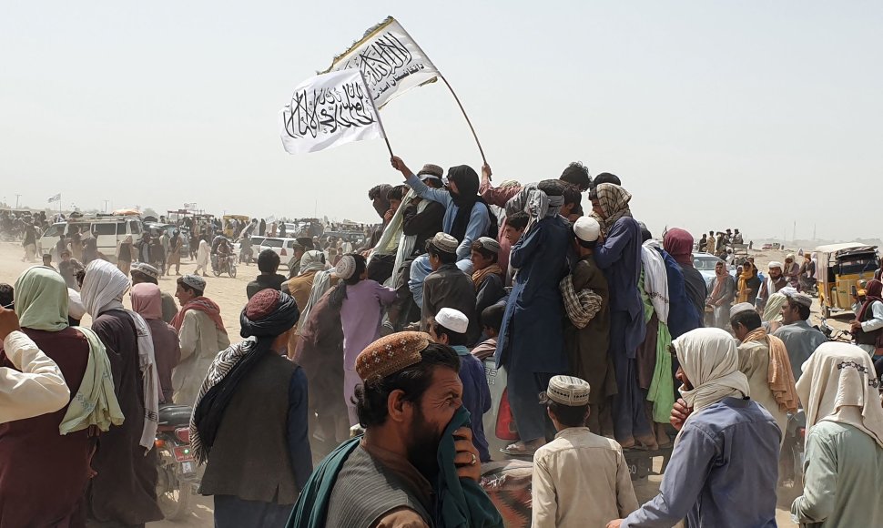 Žmonės mojuoja Talibano vėliavomis Afganistano ir Pakistano pasienyje
