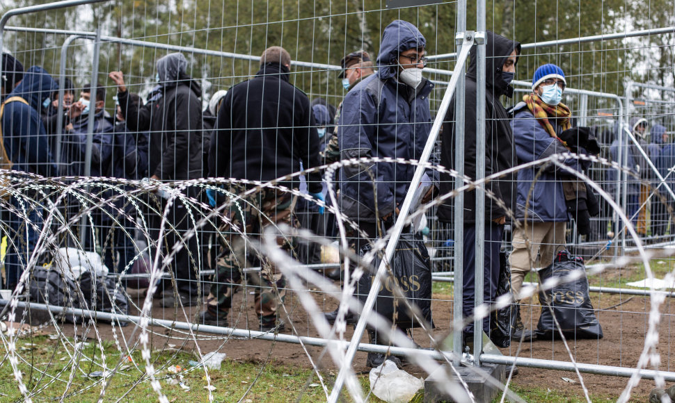 Rūdninkų (Šalčininkų raj.) laikinoje stovykloje migrantai už spygliuotos tvoros vielos eilėje laukia kol bus patikrinti jų dokumentai