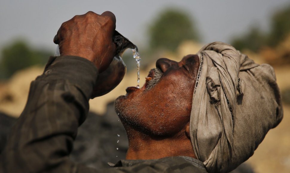 Darbininkas Indijoje geria vandenį