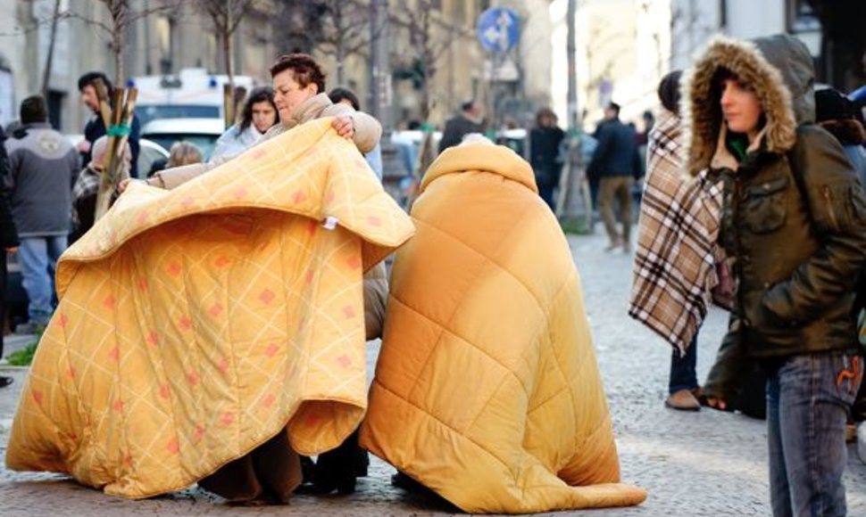 Be namų likę italai bando sušilti po antklodėmis.