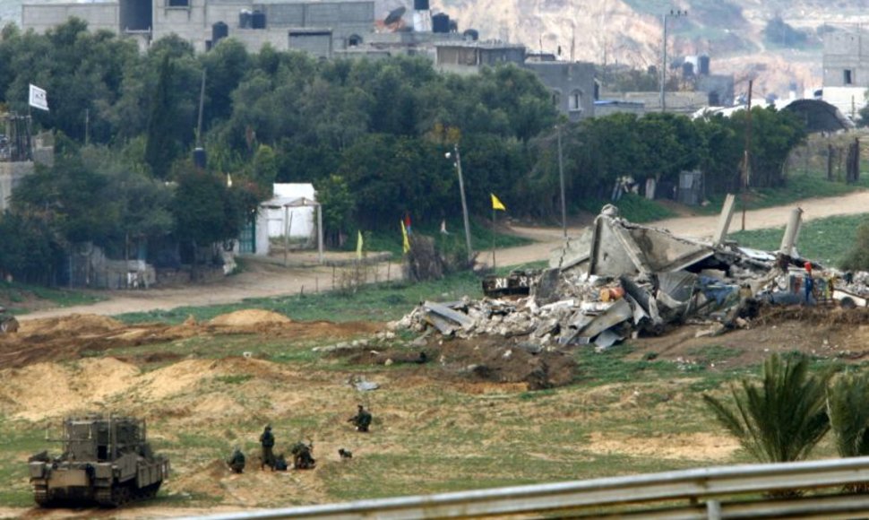 Izraelio kariai netoli sugriauto pastato