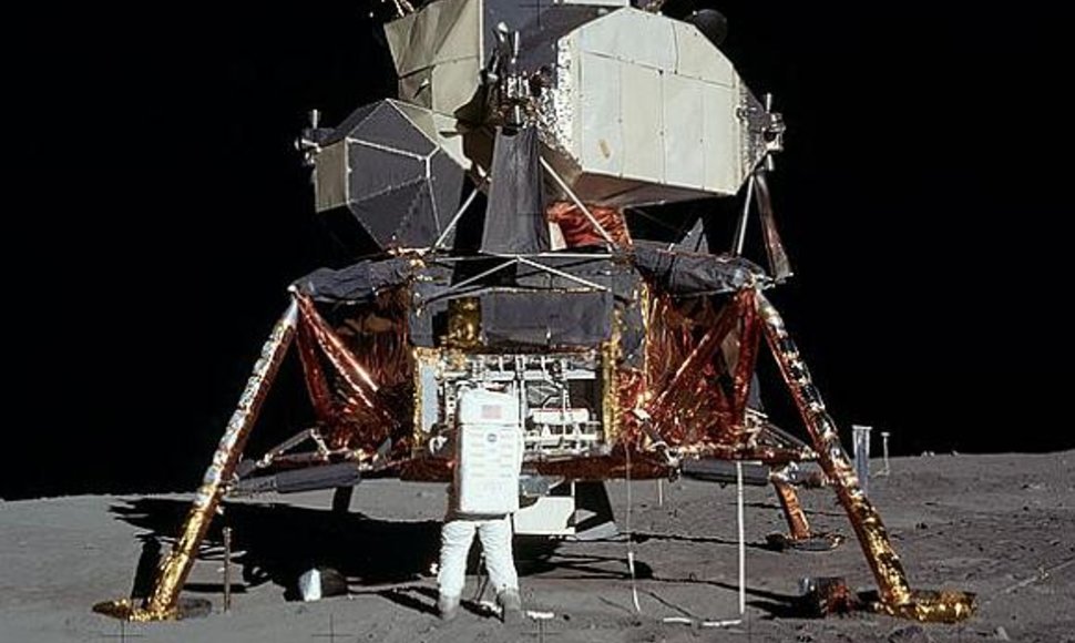 Buzzas Aldrinas iš Mėnulio modulio „Eagle“ išpakuoja instrumentus.