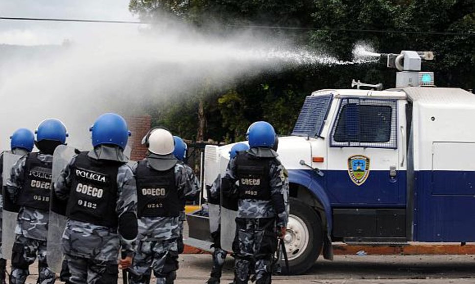 Hondūro policija naudoja vandens patrankas.