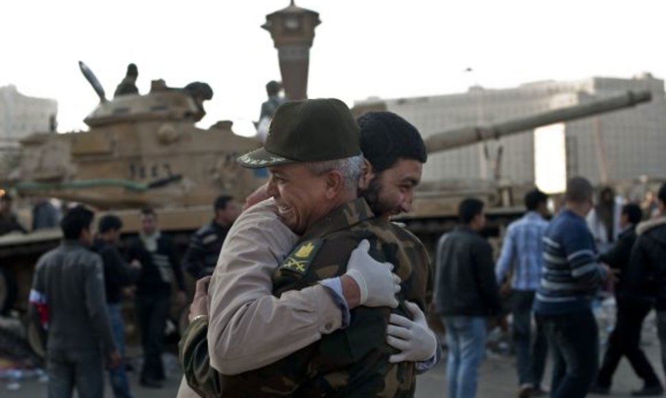 Civilis vyras ir karininkas Kaire glebėsčiuojasi sveikindami vienas kitą su revoliucijos pergale.