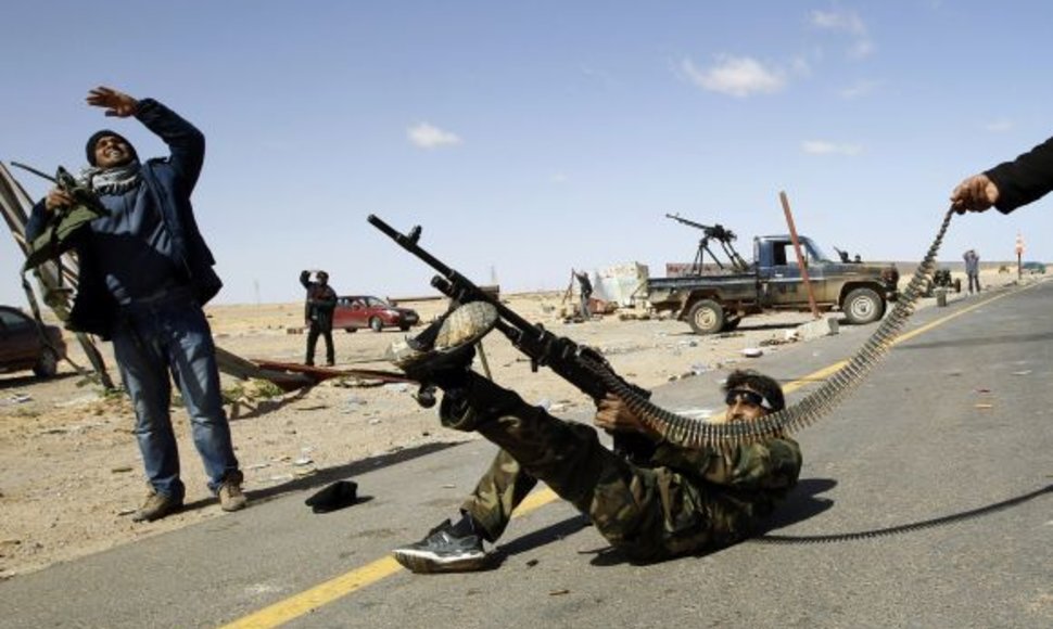 Libijos sukilėlis šaudo į vyriausybinių pajėgų lėktuvą.
