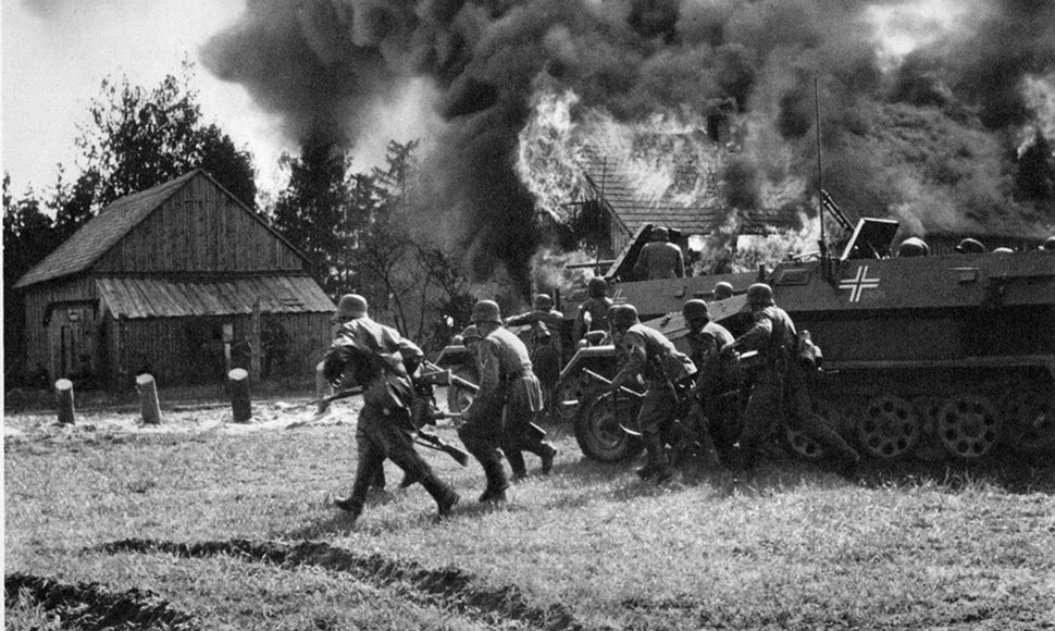 Vokiečių kariai žengia į degantį kaimą.