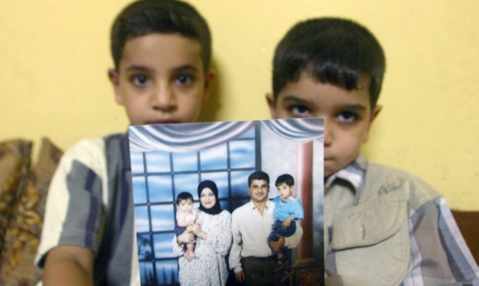 Bahos Mousos sūnūs Hassanas (kairėje) ir Ali rodo nuotrauką, kurioje visa šeima įamžinta kartu su tėčiu.