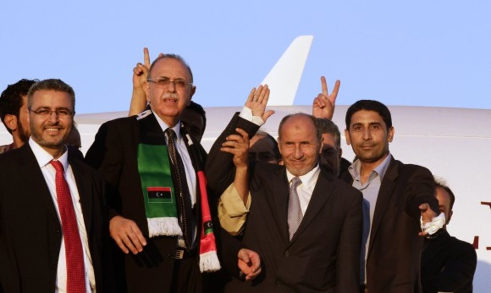 Mustafa Abdul-Jalilis (antras iš dešinės) lipa iš lėktuvo Tripolyje.