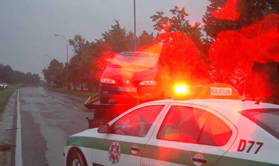 Iš avarijos vietos išvežamas sudaužytas automobilis