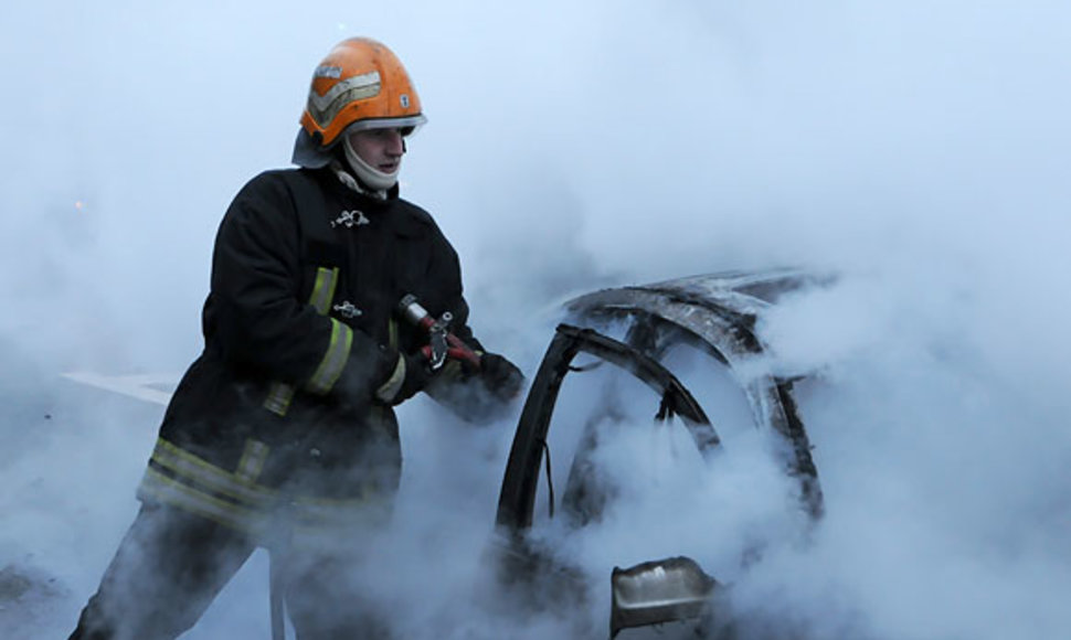 Ugniagesys gesina degantį automobilį