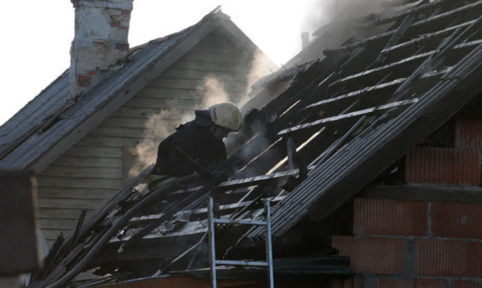 Ugniagesys ant nudegusio namo stogo