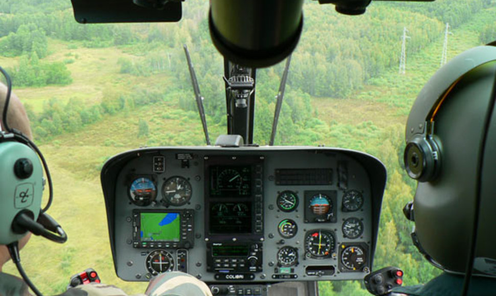 Pasieniečių sraigtasparnis skrenda virš miško